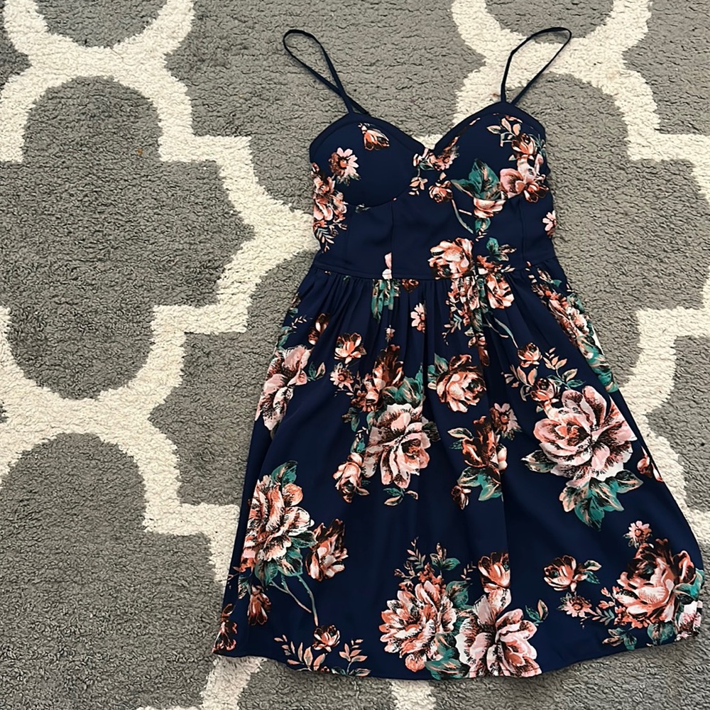 Navy blue dress with flowers in pink, green, and white; good condition.